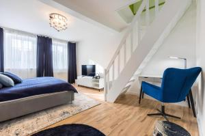 Un dormitorio con una cama, un escritorio y una silla azul. en Promenade View Apartment, en Karlovy Vary