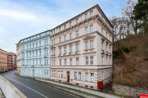 Un gran edificio blanco al costado de una calle. en Promenade View Apartment, en Karlovy Vary