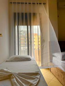 a bed in a room with a window at Vila Mare in Shëngjin