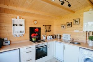 a kitchen with white cabinets and a stove at Nirvana Glamping in Tiverton