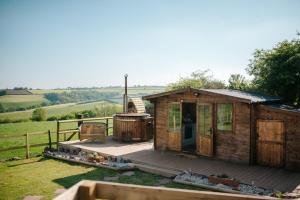 a small wooden house with a deck and a grill at Nirvana Glamping in Tiverton