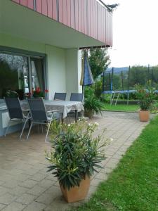 a patio with a table and chairs and plants at Ferienwohnung Wiesengrund in Überlingen