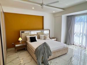 a bedroom with a large bed and a yellow wall at Aqua marine in Mombasa +42 photos