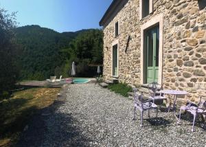 a patio with chairs and a table next to a building at Encanto Di Arlia in Fivizzano