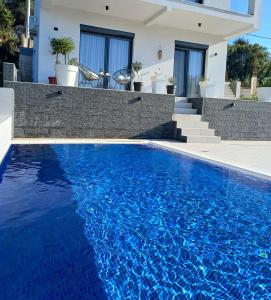 a swimming pool in front of a house at Private Villa with Pool - Utjeha Hills in Utjeha