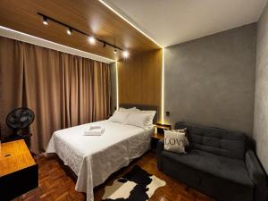 a bedroom with a bed and a couch at Top Jardins - nos Jardins sem sair da Avenida Paulista, localização imbatível! in Sao Paulo