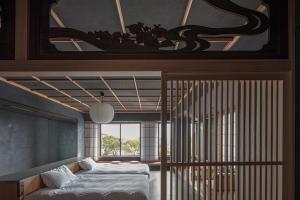 ein Schlafzimmer mit einem Bett und einem großen Fenster in der Unterkunft Ohana in Yanagawa + 82 Fotos