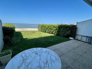 eine Terrasse mit einem Tisch und Meerblick in der Unterkunft Appartement en bord de mer avec jardin, parking et animaux acceptés à Royan - FR-1-494-63 in Royan