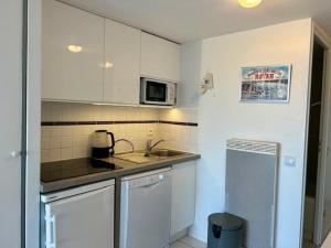 eine kleine Küche mit Spüle und Mikrowelle in der Unterkunft Appartement en bord de mer avec jardin, parking et animaux acceptés à Royan - FR-1-494-63 in Royan