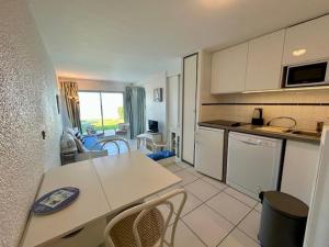 eine Küche und ein Wohnzimmer mit Tisch und Stühlen in der Unterkunft Appartement en bord de mer avec jardin, parking et animaux acceptés à Royan - FR-1-494-63 in Royan