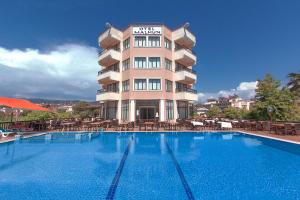 a hotel with a swimming pool in front of a building at Malhun Hotel in Fethiye