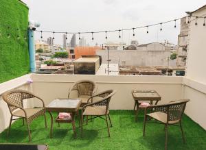 a group of chairs and tables on a balcony at Holy Hostel Sathorn in Thung Maha Mek
