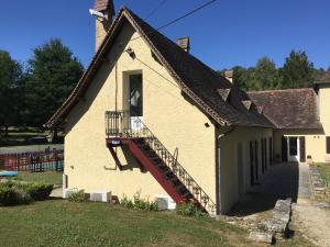 a white building with a staircase on the side of it at La maison du bonheur in Milhac