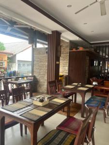 a dining room with wooden tables and chairs at SK Residence And Restaurant Patong in Patong Beach