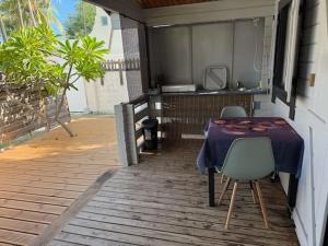 a table and chairs sitting on a porch at Bungalow Chalet du Lagon proche lagon La Saline in Saint-Paul +8 photos