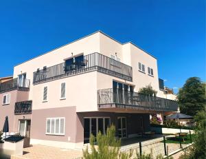 an apartment building with balconies and a blue sky at Arte Oliva in Grebaštica