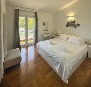sypialnia z dużym białym łóżkiem i oknem w obiekcie Villa Hosta Apartments w Hvarze