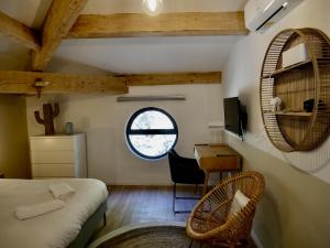 a bedroom with a bed and a desk and a window at Les Calanques - Mas des Sous-Bois in Ventabren