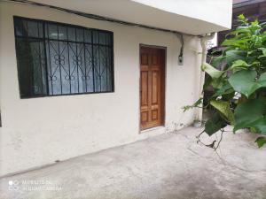 a door and a window on a white house at Residencia abuelita Carmen in Mindo