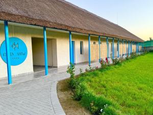 a building with a thatched roof and a grass field at Danube Delta View in Dunavăţu de Jos +66 photos