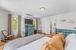 ストーニントンにあるSunny Historic 3 BR Townhouse in Downtown Mysticの大きなベッドとテレビのある寝室