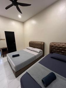 Ένα ή περισσότερα κρεβάτια σε δωμάτιο στο Redzuan Homestay (Muslim Friendly)