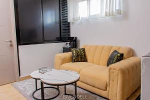 a living room with a couch and a table at Cosy 1BR Apartment along Waiyaki Way, Nairobi in Rungiri