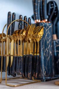 a group of gold tongs in a rack next to a vase at Cosy 1BR Apartment along Waiyaki Way, Nairobi in Rungiri +20 photos