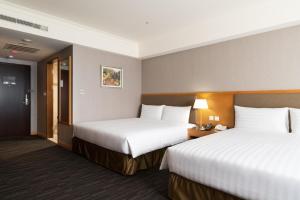 Postel nebo postele na pokoji v ubytování Fushin Hotel Taipei