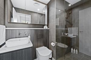 Un baño con ducha, inodoro y lavabo. en Sydney Olympic Park Escape w Car Space Height 2m, en Sídney 14 fotos más