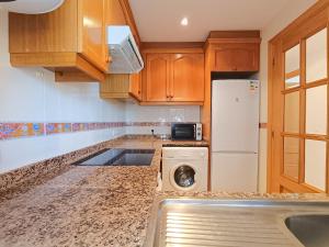 eine Küche mit einer Waschmaschine und einem Kühlschrank in der Unterkunft Ayf 3 habitaciones en 1ªlinea de playa costa in Oropesa del Mar