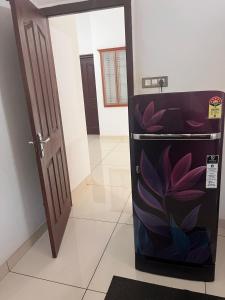 a refrigerator with a flower painted on it in a room at Safari Homestay, Malayattoor in Kodanad