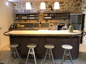 a kitchen with a bar with stools in front of it at Le Mas du Martinet in Anduze