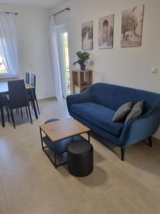 a living room with a blue couch and a table at Apartment Oliva in Krk