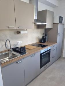 a kitchen with white cabinets and a sink and a stove at Apartment Oliva in Krk