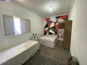 a small bedroom with two beds and a window at Casa Sobrado com Piscina in Bertioga