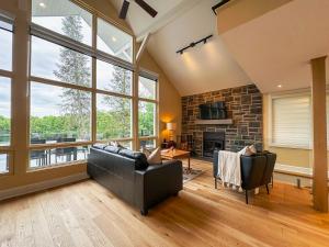 a living room with a couch and a fireplace at Le Mimosa 32 nights min ExitChalets Lake in Morin Heights