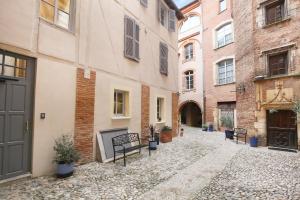 an alley in an old building with benches and buildings at CHAL6 Apt moderne à 200m du Capitole in Toulouse