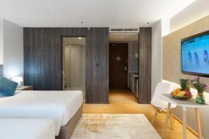 Un dormitorio con una cama y una mesa con televisión. en Perfect Studio 3 pools Nai Harn, en Rawai Beach