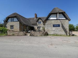 an old stone house with a thatched roof at Spindle in Witney