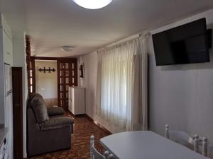 a living room with a television and a couch and a chair at Caticobas in San Pedro