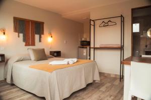 a bedroom with a bed with two towels on it at Alameda Reserve Apart in El Calafate