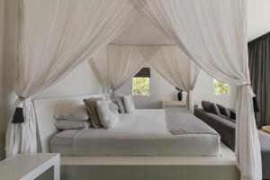 une chambre avec un grand lit blanc avec des rideaux dans l'établissement Beachfront Villa in Bali, à Cemagi 44 autres photos
