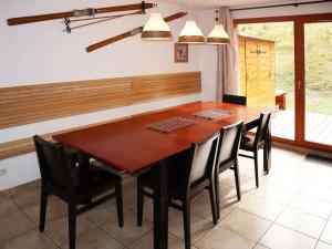 レ・ゾルにあるSuperbe chalet pour 10 pers. avec piscine, sauna, cheminée, terrasse, skis aux pieds - Les Orres 1800 - FR-1-322-118のダイニングルーム(木製テーブル、黒い椅子付)