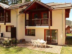 レ・ゾルにあるSuperbe chalet pour 10 pers. avec piscine, sauna, cheminée, terrasse, skis aux pieds - Les Orres 1800 - FR-1-322-118のデッキにテーブルと椅子が備わる家