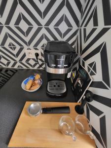 a coffee maker on a counter next to a cutting board at Les couleurs de Schiltigheim - Aux portes de Strasbourg - Parlement in Schiltigheim +5 photos