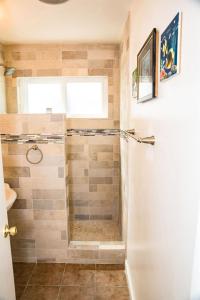 a bathroom with a shower with a glass door at 1 Bed Beach Bungalow #130 in Carpinteria