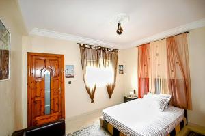 a bedroom with a bed and a wooden door at Vintage apartment EL JADIDA in El Jadida