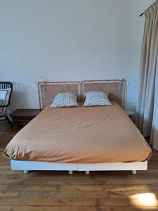 a bed with a metal headboard and pillows on it at Studio plein centre in Dol-de-Bretagne