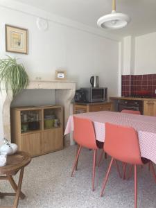 a kitchen with a table and chairs and a fireplace at Le Clos de Marguerite in Mellecey